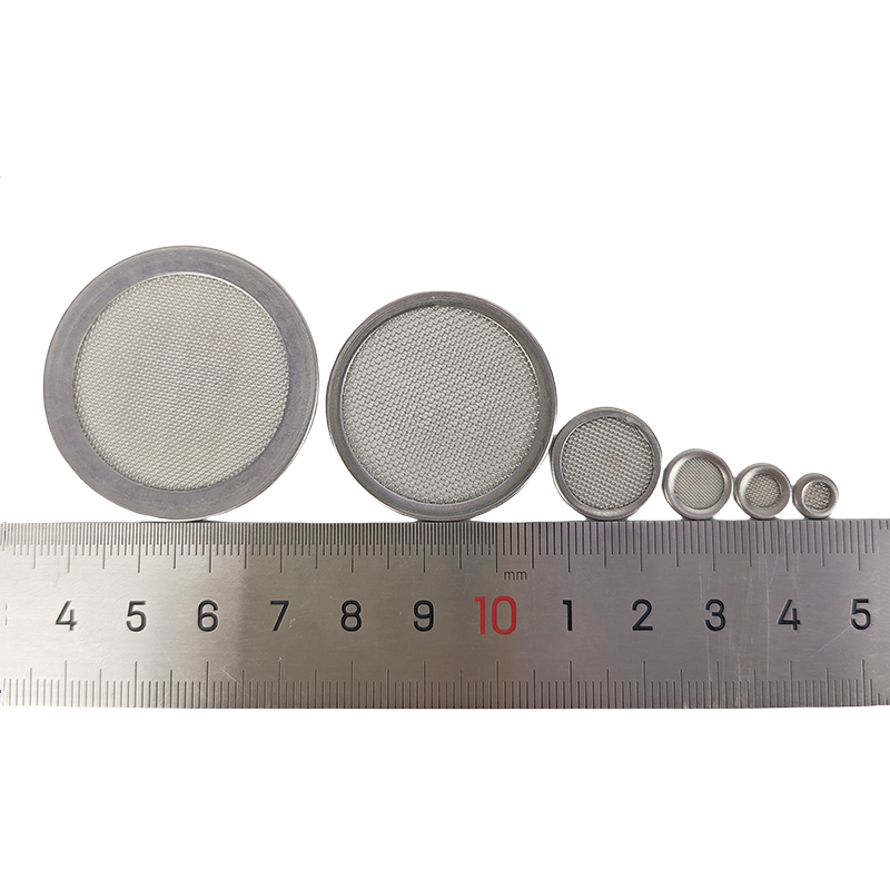 Stainless steel filter discs lined up from small to large next to a ruler to show precise diameter options
